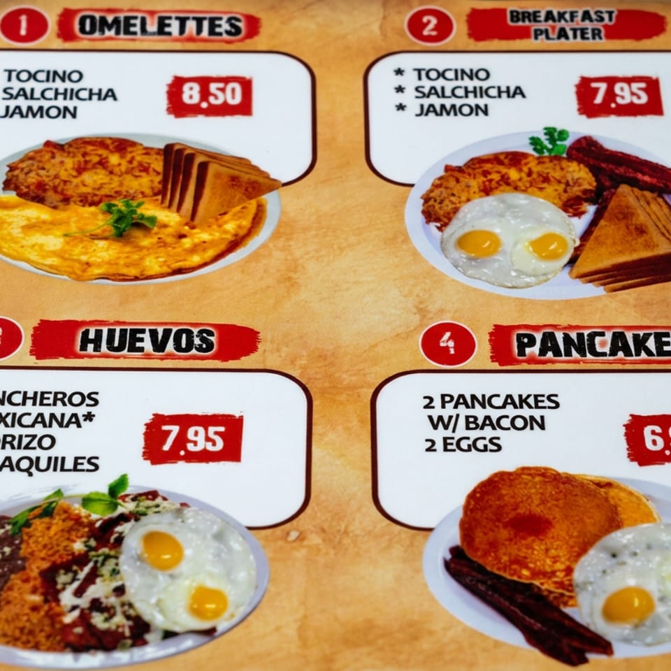 Breakfast menu page displaying omelets, a breakfast platter, huevos dishes, and pancakes with eggs and bacon.
